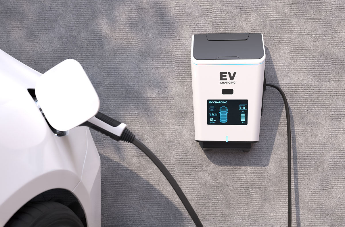 Close-up of a modern electric vehicle charging cable plugged into a wall-mounted home charging station.